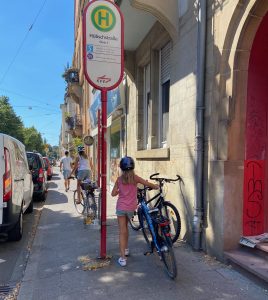 Kinder schieben ihre Fahrräder auf dem Bürgersteig